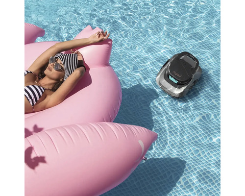 Scéna so ženou na nafukovacom plameniakovi v bazéne a robotický čistič bazéna