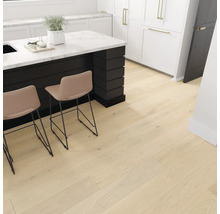 Svetlá drevená podlaha v kuchyni s kuchynským ostrovom a barovými stoličkami.