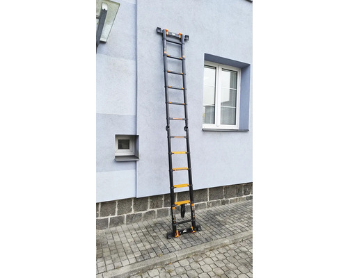Rozložený teleskopický rebrík z kovu pri stene domu