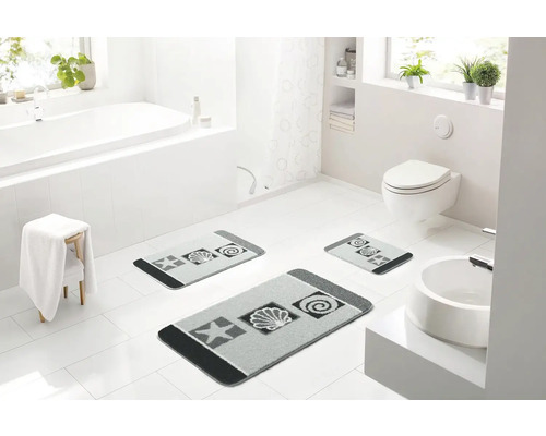 Svetlá kúpeľňa s vaňou, toaletou, umývadlom a súpravou kúpeľňových predložiek so sivým vzorom