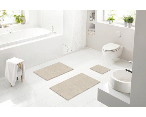 Svetlá kúpeľňa s vaňou, toaletou, umývadlom a súpravou troch kúpeľňových predložiek