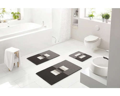 Svetlá kúpeľňa s vaňou, umývadlom, toaletou a súpravou troch kúpeľňových koberčekov s geometrickým vzorom