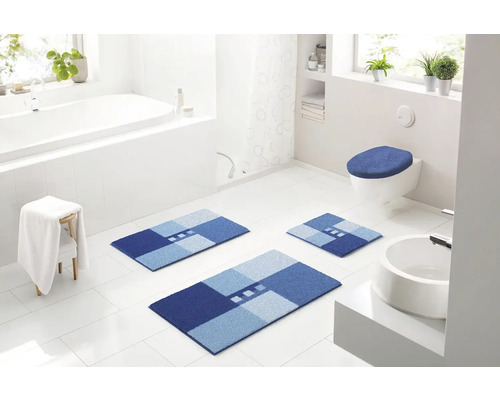 Svetlá kúpeľňa s vaňou, umývadlom, toaletou a modrými kúpeľňovými predložkami