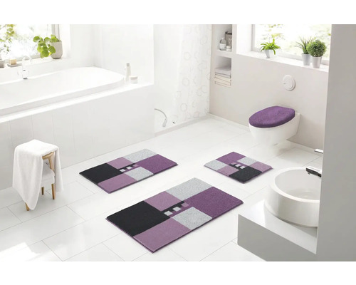 Svetlá kúpeľňa s vaňou, umývadlom, toaletou a súpravou kúpeľňových predložiek z troch kusov s geometrickým vzorom