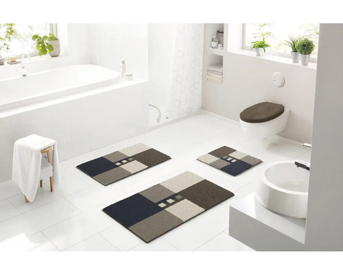 Kúpeľňa s vaňou, umývadlom, toaletou a súpravou kúpeľňových predložiek s geometrickým vzorom