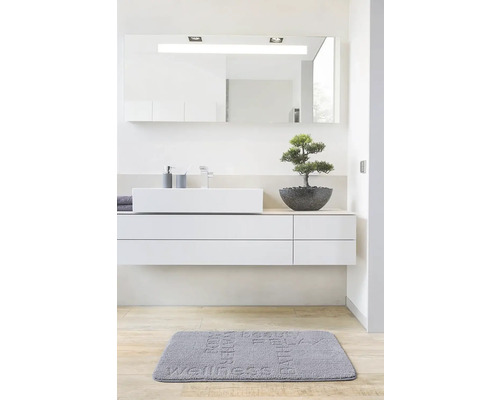 Moderná kúpeľňa s umývadlom, zrkadlom a kúpeľňovou predložkou