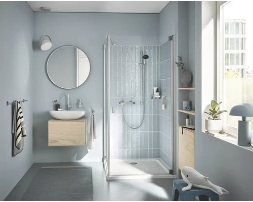 Svetlá kúpeľňa so sprchou, umývadlom, zrkadlom a doplnkami pre relaxačnú atmosféru.