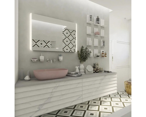 Svetlá kúpeľňa s ružovým umývadlom, osvetleným zrkadlom a dekoratívnymi policami.