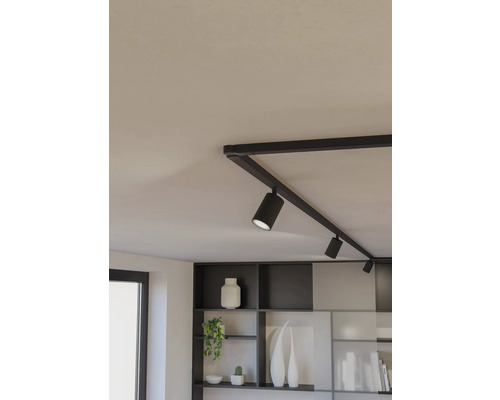 Čierny koľajnicový systém s niekoľkými bodovými svetlami na strope.