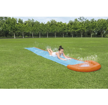 Dievča sa kĺže na vodnej šmýkačke v záhrade