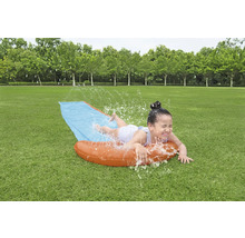 Dievča sa zabáva na vodnej šmykľavke v záhrade