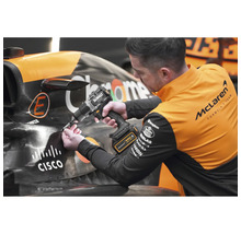 Muž pracuje s akumulátorovou vŕtačkou Dewalt na pretekárskom aute.