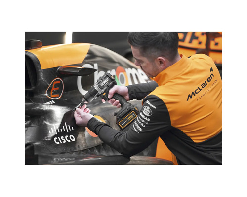 Muž pracuje s akumulátorovou vŕtačkou Dewalt na pretekárskom aute.