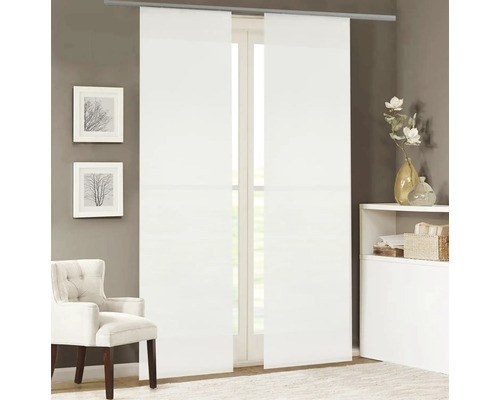 Dva biele posuvné závesy pred oknom, doplnené kreslom a dekoračnými predmetmi v miestnosti.