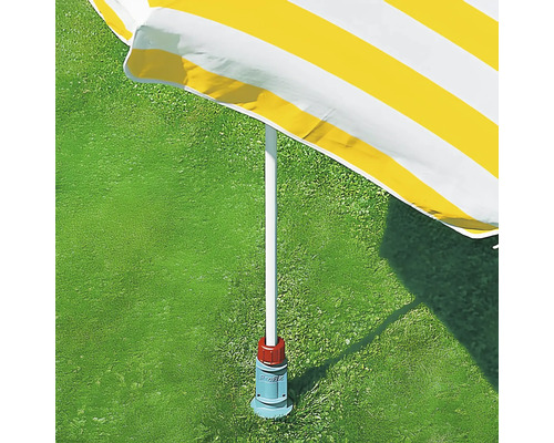 Žlto pruhovaný slnečník so stojanom na trávniku