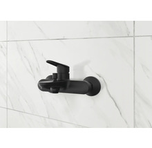 Čierna sprchová batéria na bielej mramorovej stene