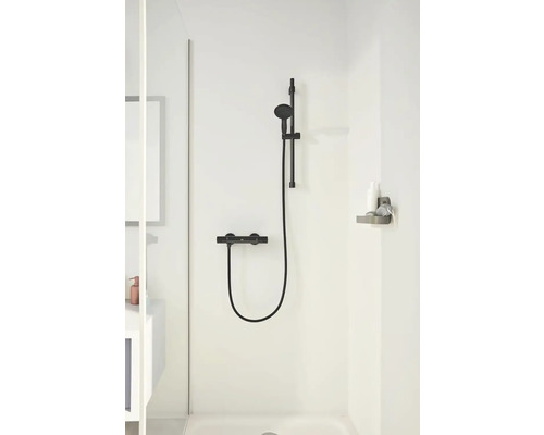 Sprchová armatúra v kúpeľni so sprchovou hlavicou, tyčou a termostatom.