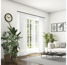 Svetlá obývacia izba s pohovkou, konferenčným stolíkom, izbovými rastlinami, hodinami a posuvným závesom pred oknom.