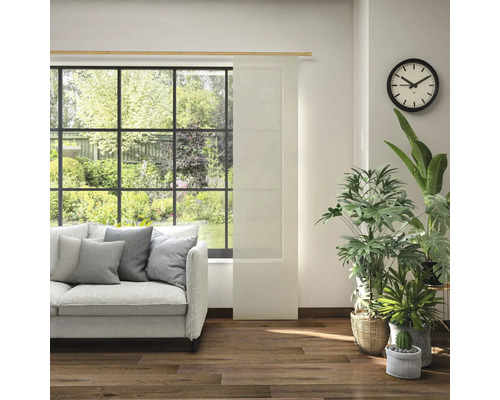 Obývacia izba s pohovkou, izbovými rastlinami, hodinami a posuvným panelom pred oknom