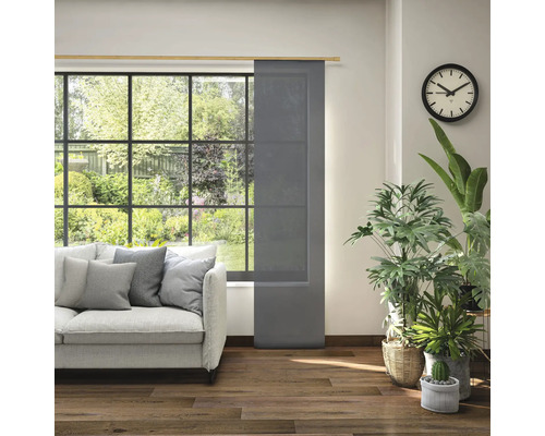 Obývacia izba s posuvným panelom v okne, pohovkou a izbovými rastlinami