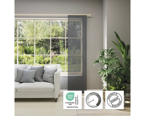 Obývacia izba s oknom, pohovkou a priehľadným posuvným závesom s pečaťou Öko-Tex Standard 100 a pečaťou Design from Germany