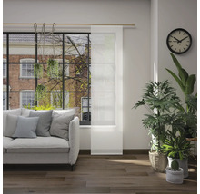 Obývacia izba s pohovkou, izbovými rastlinami, hodinami a posuvným panelom pred oknom