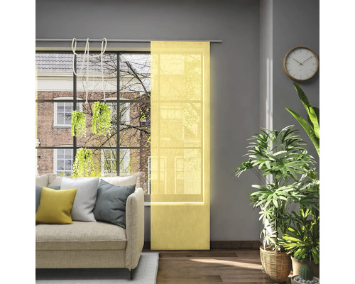 Obývacia izba s posuvným závesom v okne, pohovkou, izbovými rastlinami a nástennými hodinami