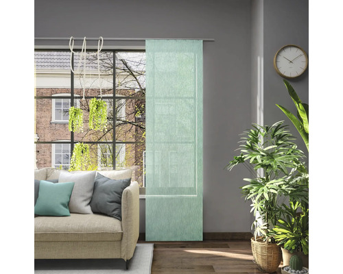 Obývacia izba s pohovkou, izbovými rastlinami, hodinami a posuvným závesom