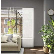 Obývacia izba s pohovkou, izbovými rastlinami a posuvnou záclonou pred oknom