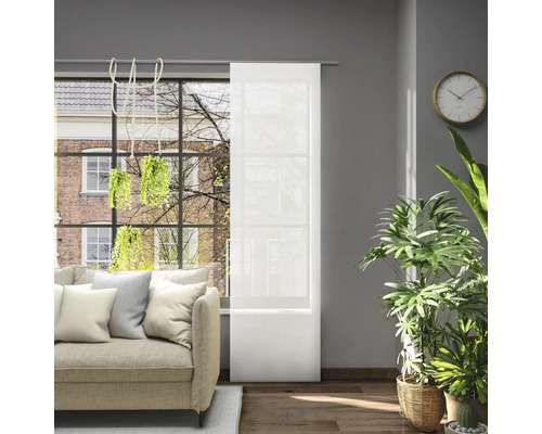 Obývacia izba s pohovkou, izbovými rastlinami a posuvnou záclonou pred oknom