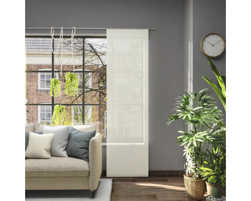 Obývacia izba s posuvným závesom na okne, pohovkou a izbovými rastlinami pre svetlú a priateľskú atmosféru.