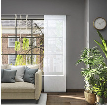 Obývacia izba s pohovkou a priehľadným posuvným závesom na okne na reguláciu svetla.