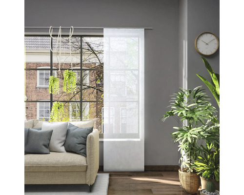 Obývacia izba s pohovkou a priehľadným posuvným závesom na okne na reguláciu svetla.