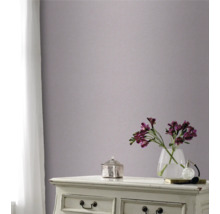 Dekoratívna izba so vzorovanou tapetou na stene, komodou, vázou s kvetmi a závesom v okne.