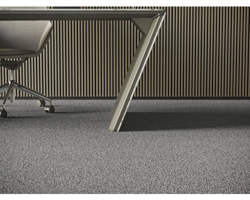 Detailný pohľad na sivý koberec v kancelárii so stolom a kancelárskou stoličkou.