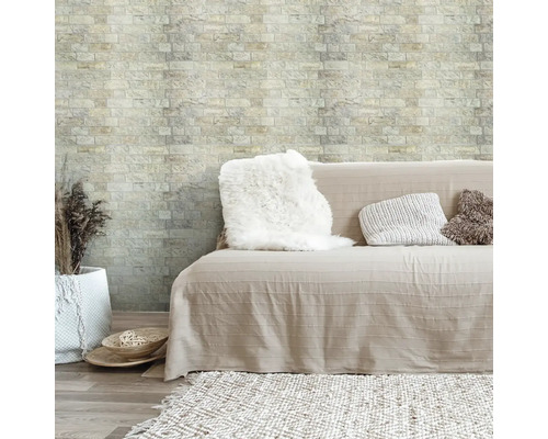 Útulná obývacia izba s pohovkou, vankúšmi a tapetou z tehál.