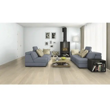 Obývacia izba so sivými sedačkami, krbovými kachľami, konferenčným stolíkom a svetlou drevenou podlahou