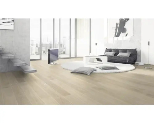 Svetlá obývacia izba s drevenou podlahou, schodiskom, sedením, okrúhlym kobercom a televízorom