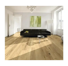 Svetlá obývacia izba s drevenou podlahou, pohovkou a umeleckým dielom