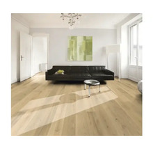 Obývacia izba s drevenou podlahou, pohovkou a umeleckým dielom