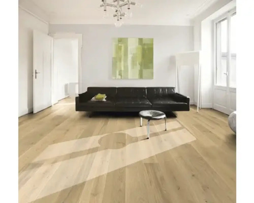 Obývacia izba s drevenou podlahou, pohovkou a umeleckým dielom