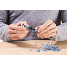 Osoba lepí slúchadlá sekundovým lepidlom.