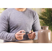 Muž opravuje keramickú vázu lepidlom