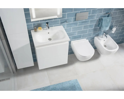 Moderná kúpeľňa s umývadlom, toaletou a bidetom pred modrou stenou