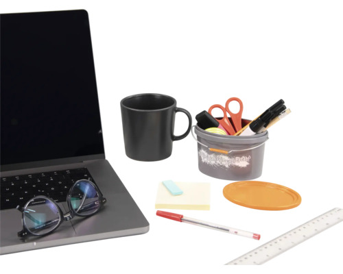 Scéna s notebookom, šálkou, vedierkom s kancelárskymi potrebami, lepiacimi poznámkami, perom a pravítkom.