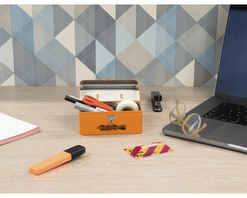 Scéna s otvorenou oranžovou debnou na náradie, kancelárskymi potrebami a notebookom na stole