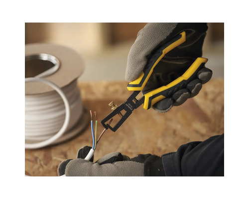 Osoba používa odizolovacie kliešte na kábli. V pozadí je cievka kábla.