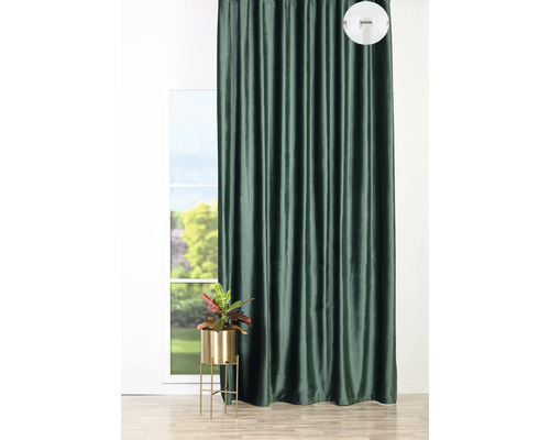 Dekoratívny tmavý záves pred oknom s izbovou rastlinou na stojane na rastliny.