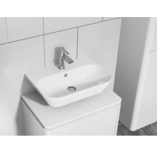 Moderné kúpeľňové umývadlo s batériou na skrinke s rebrovanou štruktúrou.