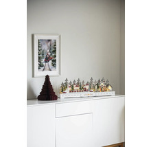 Dekoratívna vianočná scéna s osvetlenou zimnou krajinou, papierovým stromom a obrázkom vlaku na bielej skrini